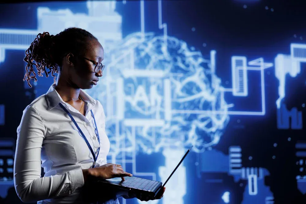 A woman in white, holding a laptop